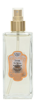 A clear glass spray bottle of a La sultan de saba, featuring a gold pump collar and a decorative orange label on a white background.