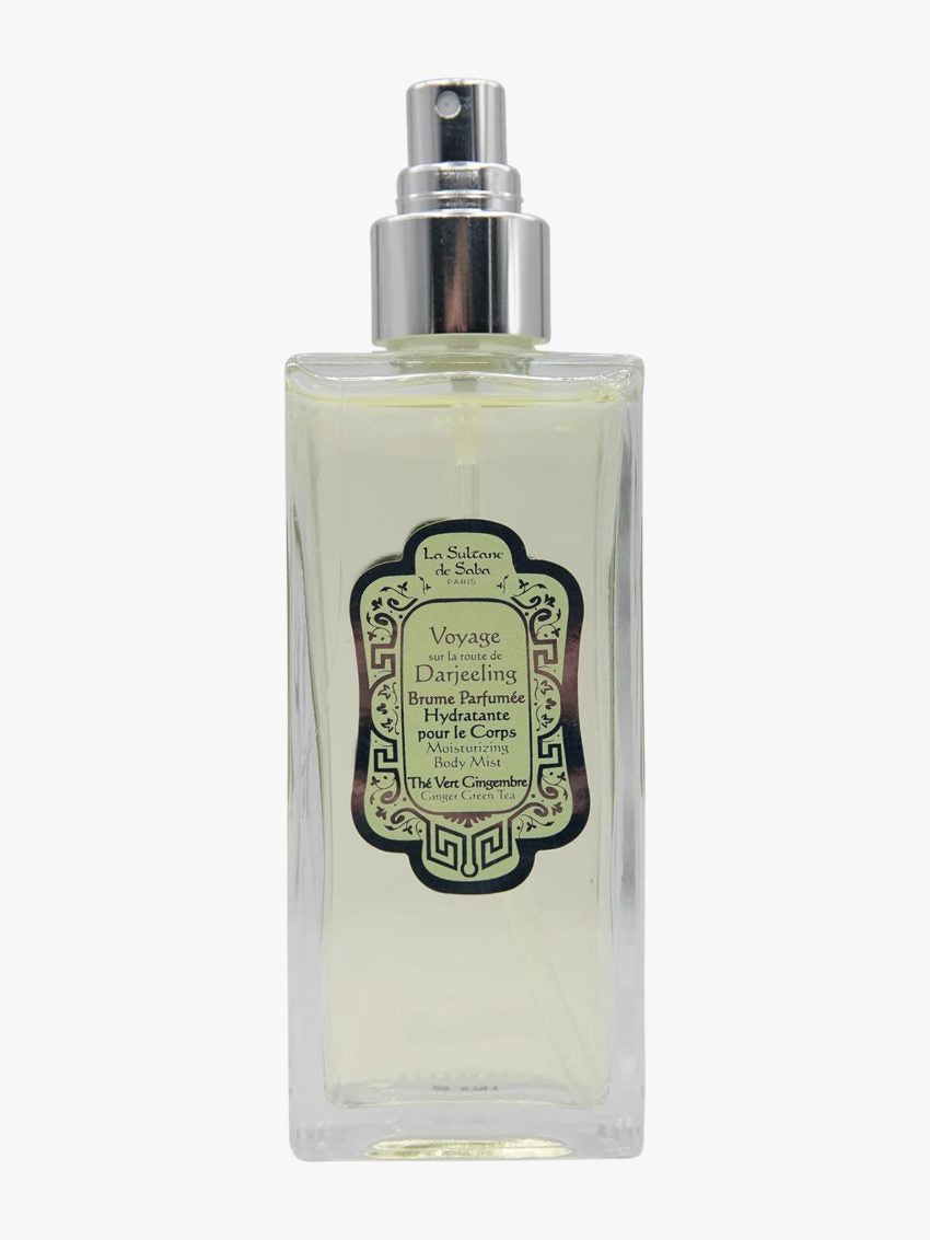 A rectangular glass perfume bottle with a silver spray nozzle and a decorative black and green label, containing a pale yellow liquid, shown against a plain white background.