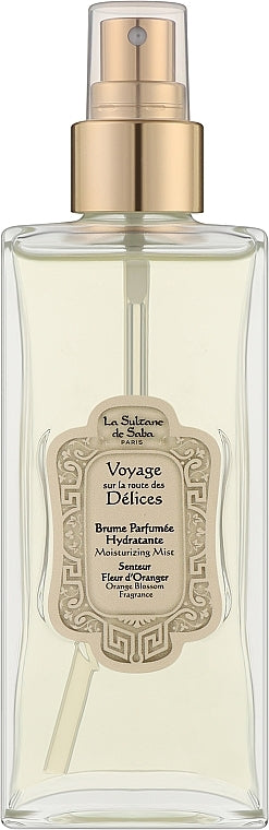 A clear glass bottle of Le Siffleur de Salin 'Voyage des Petits Champs' perfume spray with a gold pump and a beige decorative label, set against a plain white background.