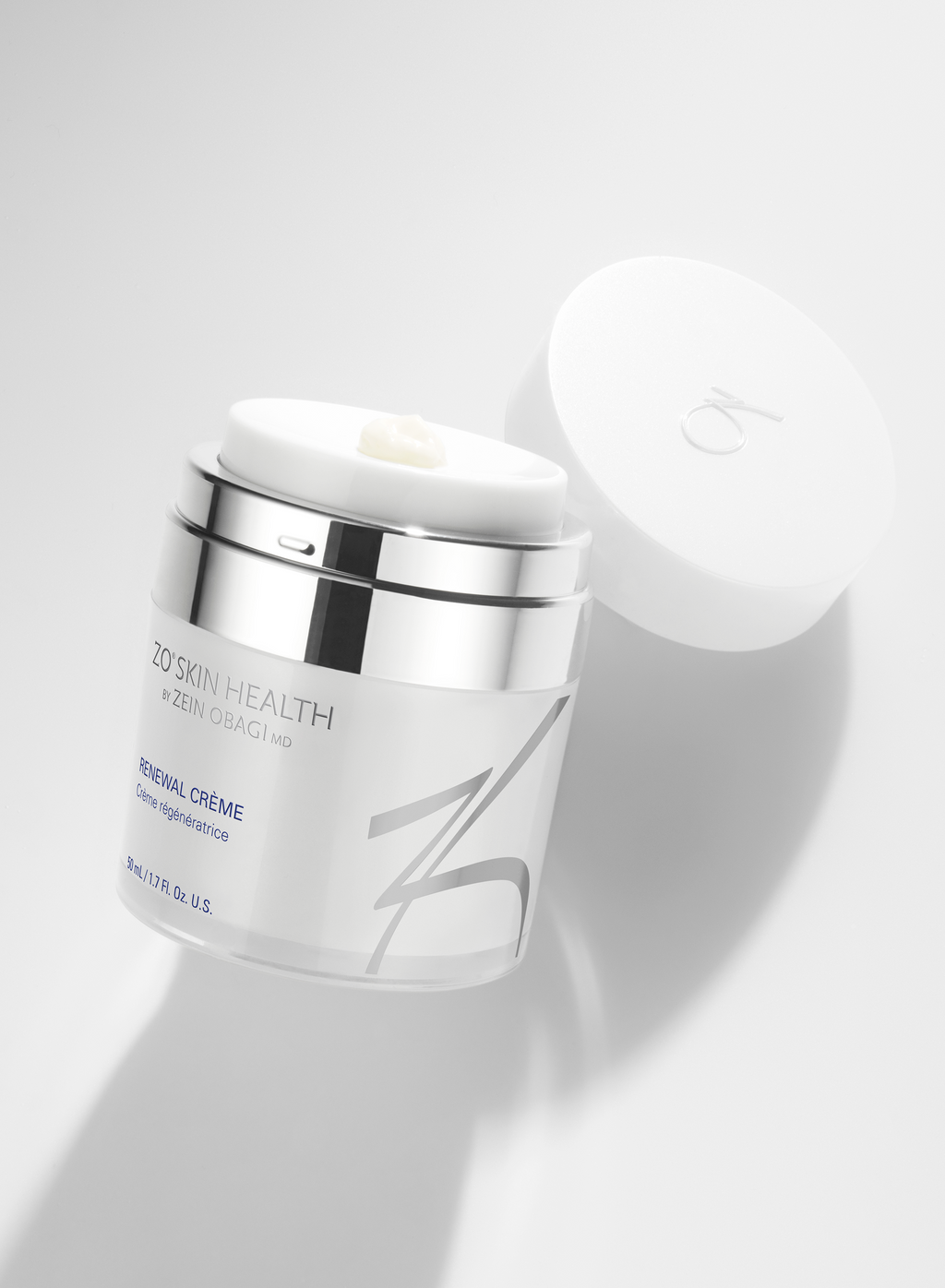 Cosmetic cream jar with a silver cap on a white background